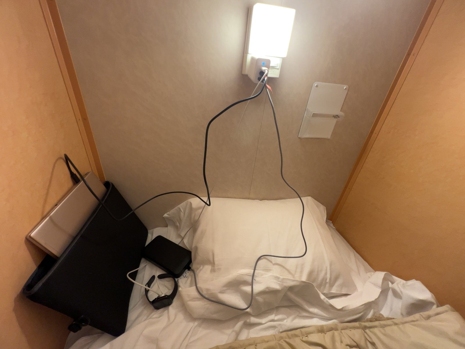 客室のベッドでPCを開いて充電