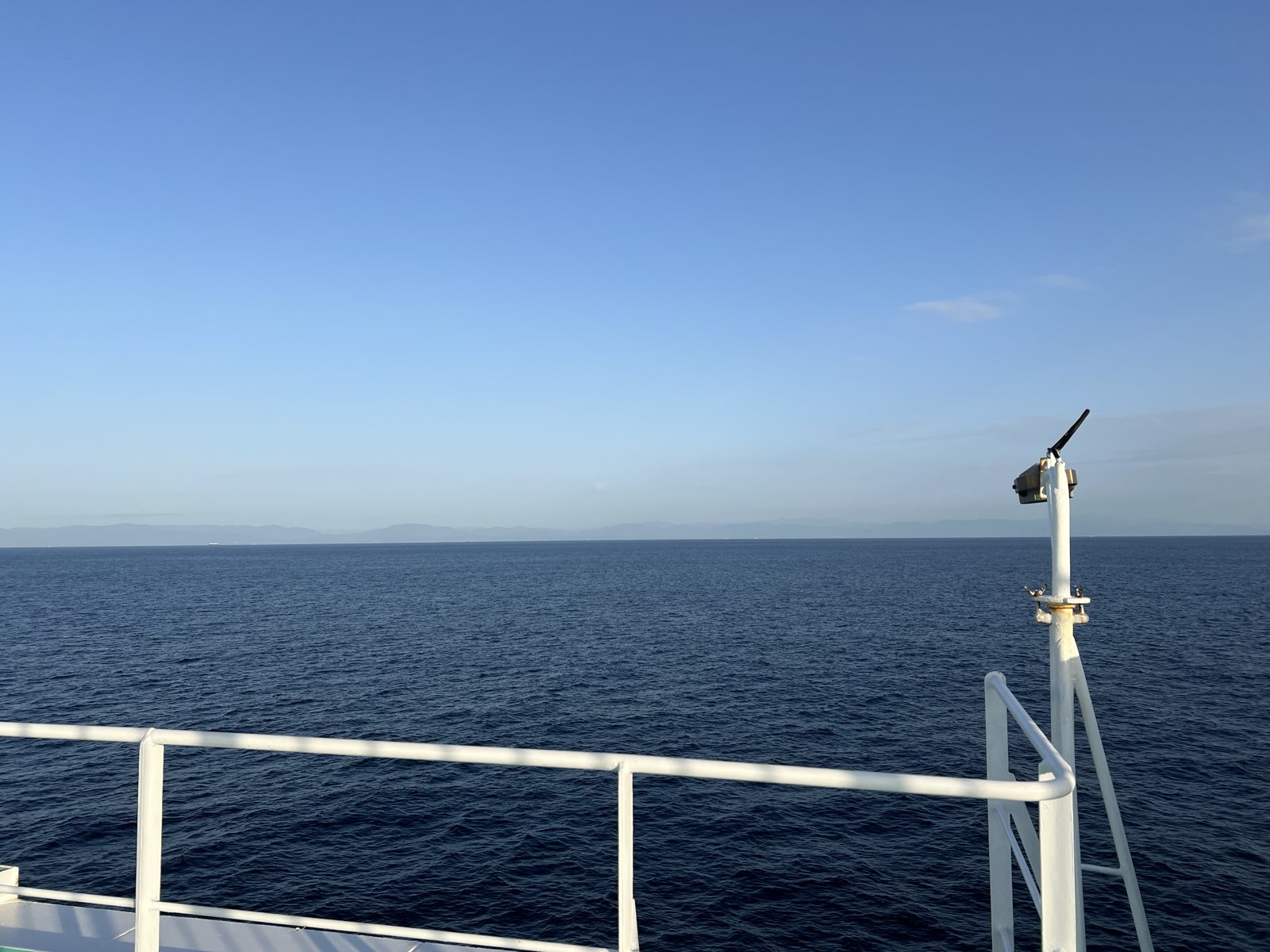 紺碧の海と、水平線に浮かぶ陸の影