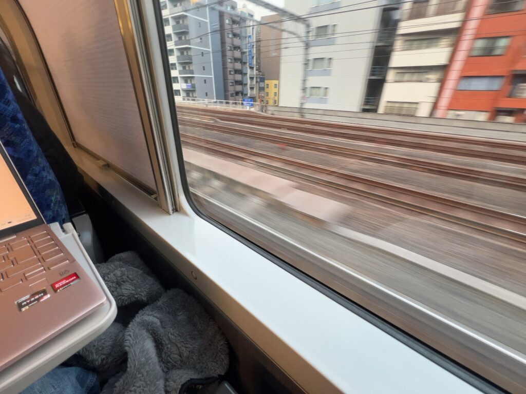 グリーン車のテーブルにノートPCを置いた窓際の席